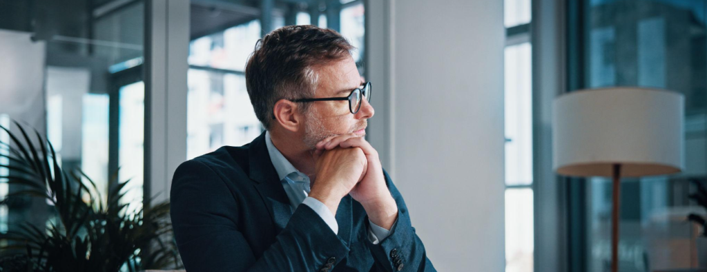 cadre barbu avec des lunettes a son bureau